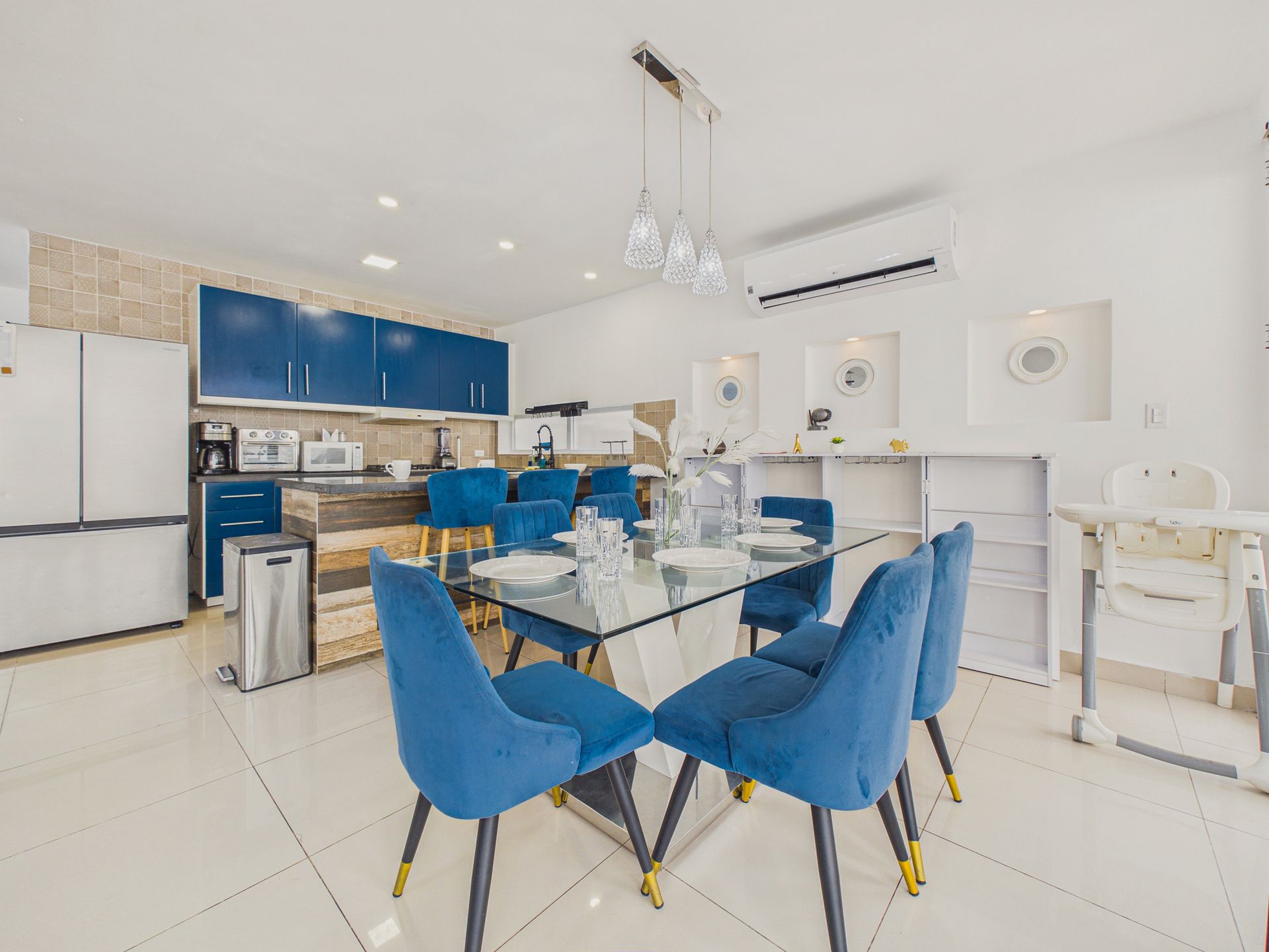 Comedor moderno con sillas de terciopelo azul cobalto en Casa Roja